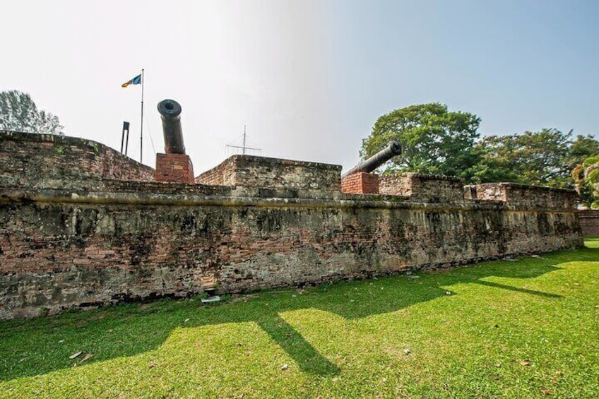 A historic fort with cannons, brick walls, and a flag. 5
