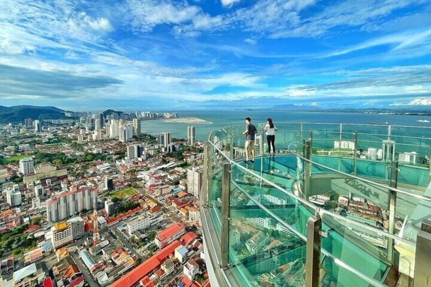 A cityscape with a glass bridge overlooking the ocean. 1