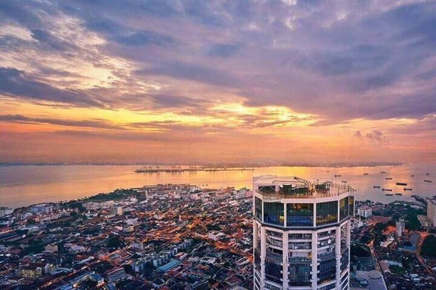A coastal cityscape at sunset with a prominent tower in the foreground. 4