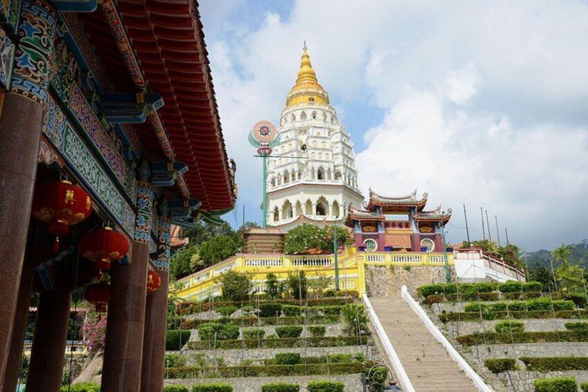 A temple with a golden spire, intricate architecture, and terraced gardens. 1