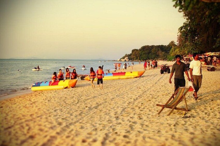 A beach with people, inflatable boats, and a lifeguard stand. 2