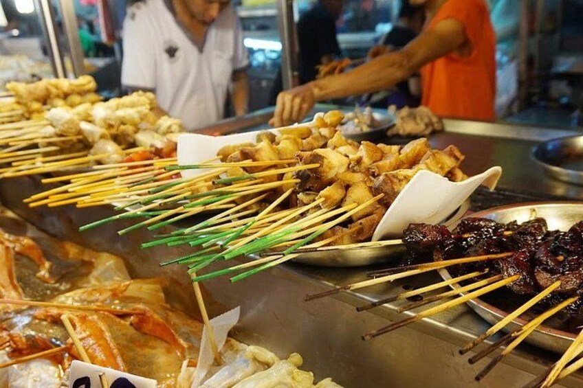 A food stall with skewers of grilled meat and vegetables. 5