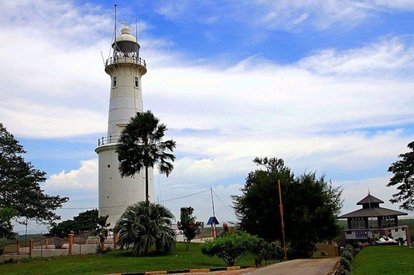 A lighthouse, palm trees, and a small building. 3
