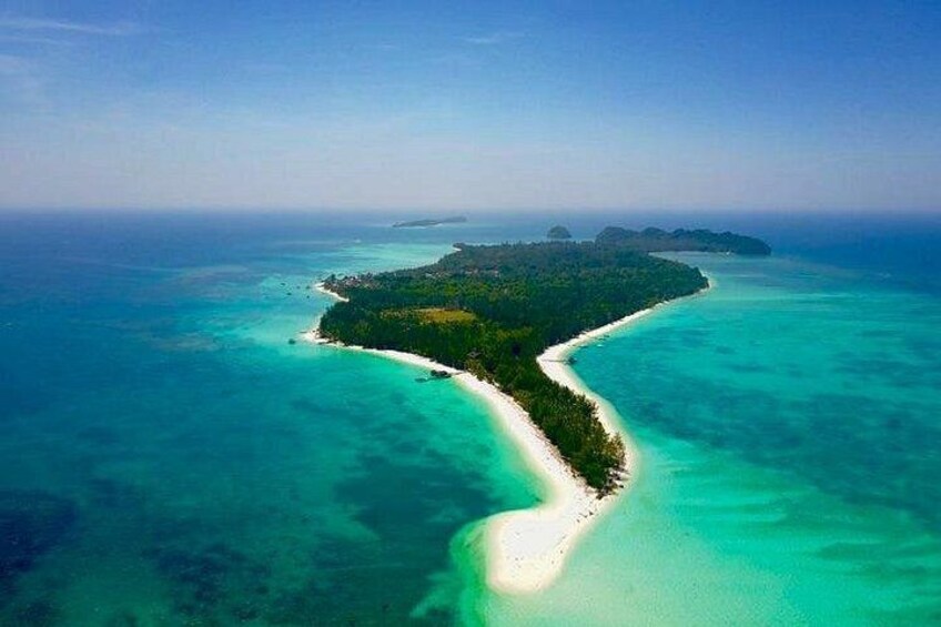 A tropical island with a white sandy beach, clear turquoise waters, and lush green vegetation. 5