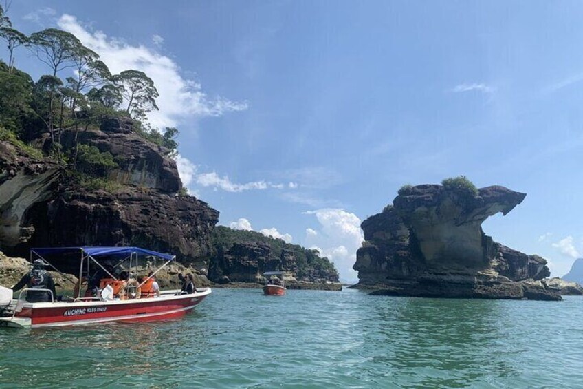 A boat named 'ZUCCHERO' near rocky cliffs and clear blue water. 2