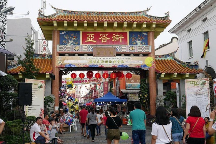 A traditional Chinese gate with red lanterns and a crowd of people. 2