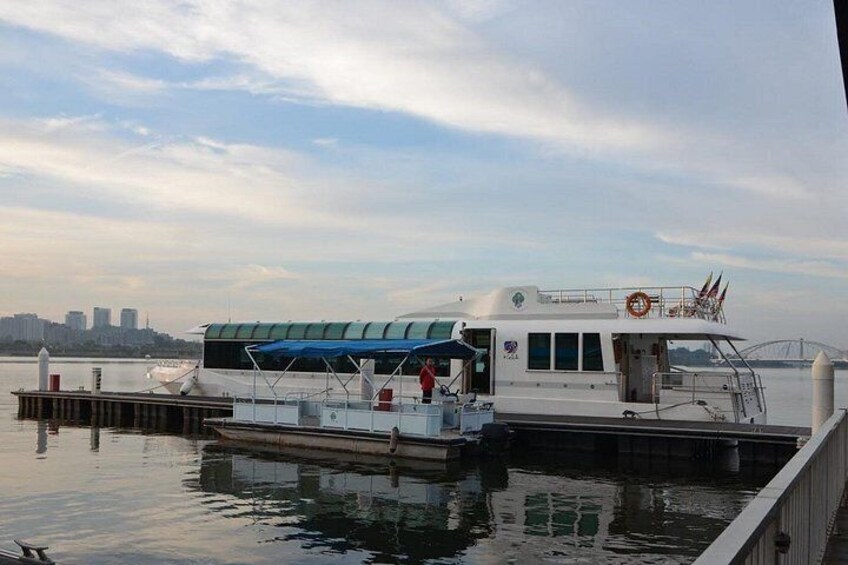 A white boat docked at a pier with a city skyline in the background. 4