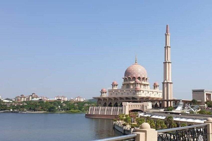 A mosque with a large dome and minaret by a body of water. 3