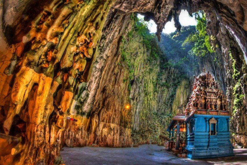 A temple nestled in a cave with a blue shrine and natural rock formations. 2
