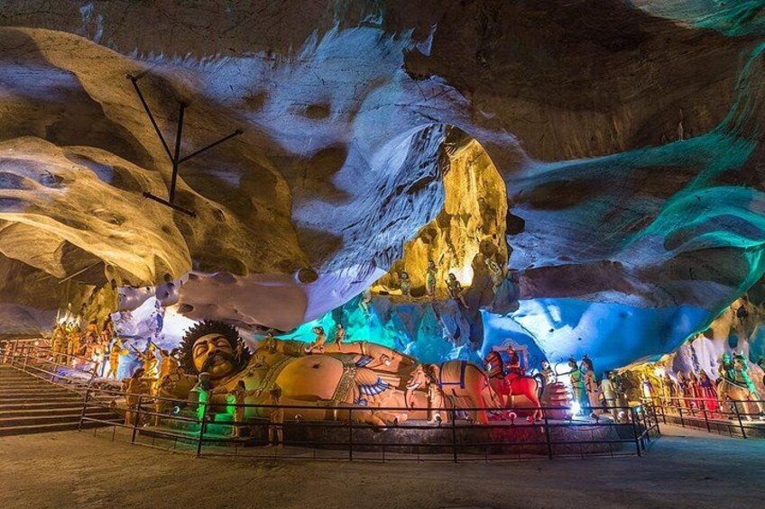 An ice cave with illuminated rock formations and a central sculpture. 5