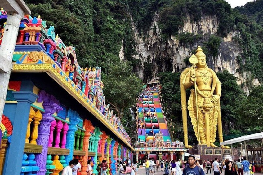 A colorful temple with a large golden statue and a multi-tiered pagoda. 4