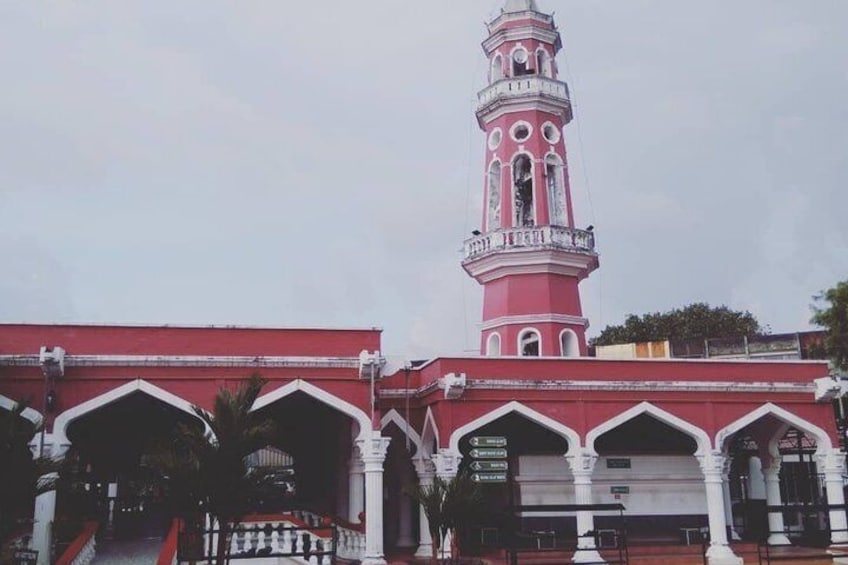 A pink and white church with a bell tower and arched windows. 3