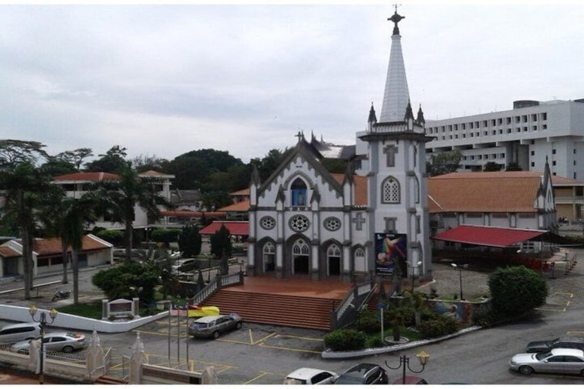 A church with a tall spire, a clock tower, and a red-roofed building in the background. 4