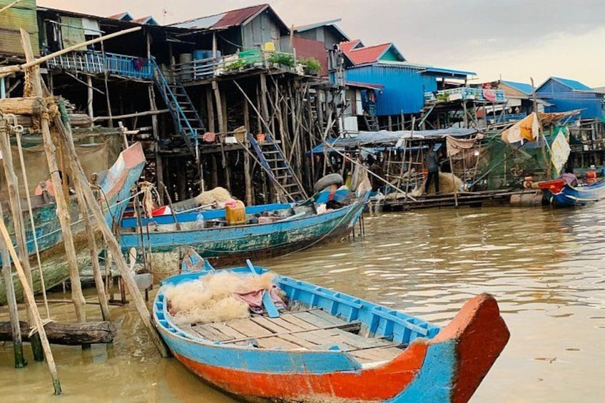 A waterway with boats, wooden structures, and houses. 3