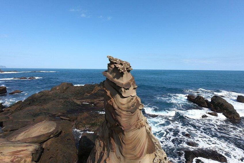 A rock formation resembling a human figure by the sea. 4