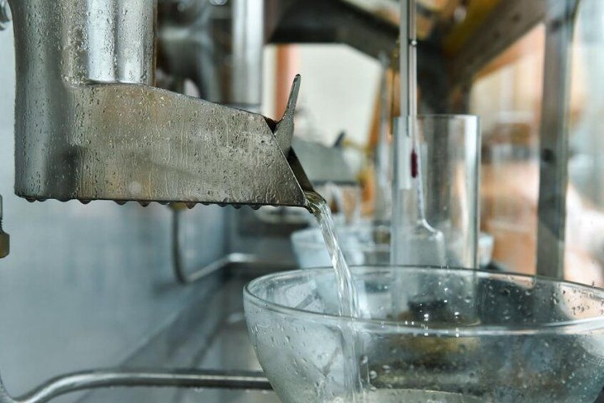 En vattenkran i metall som fyller en glasskål med vatten. 2