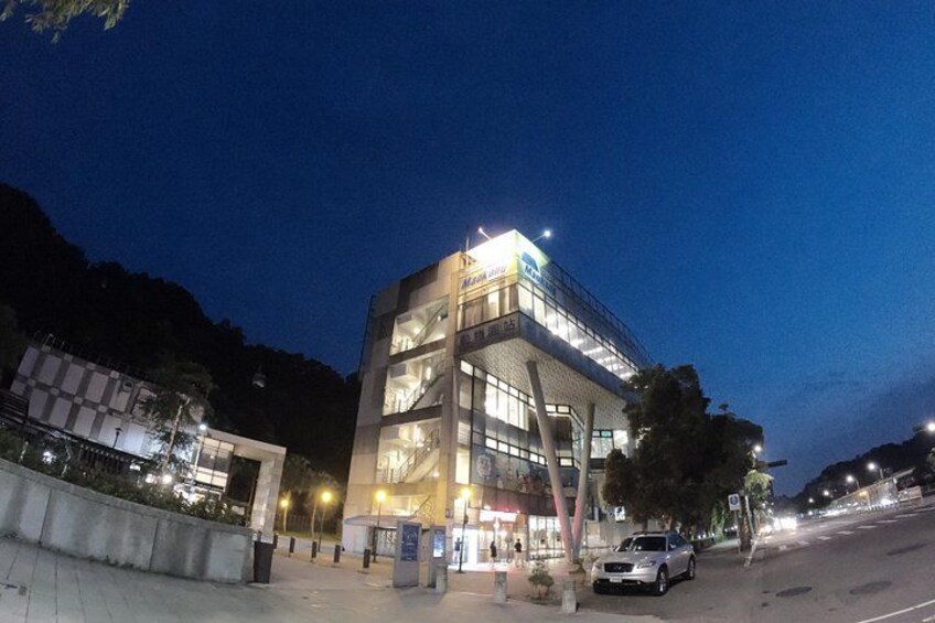 A modern building with illuminated signage at dusk. 4