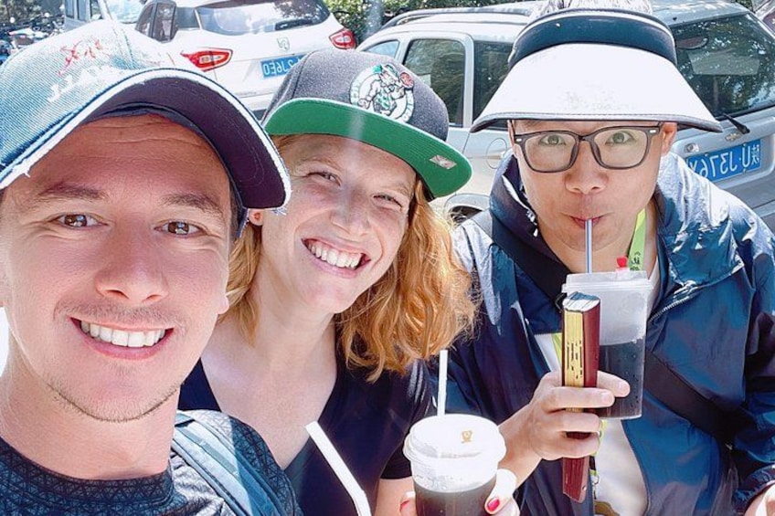 Three people wearing hats and jackets, holding drinks. 4