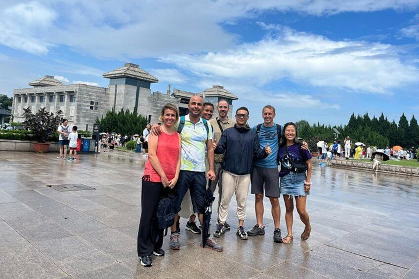 A group of people posing in front of a large building with a dome and columns. 3
