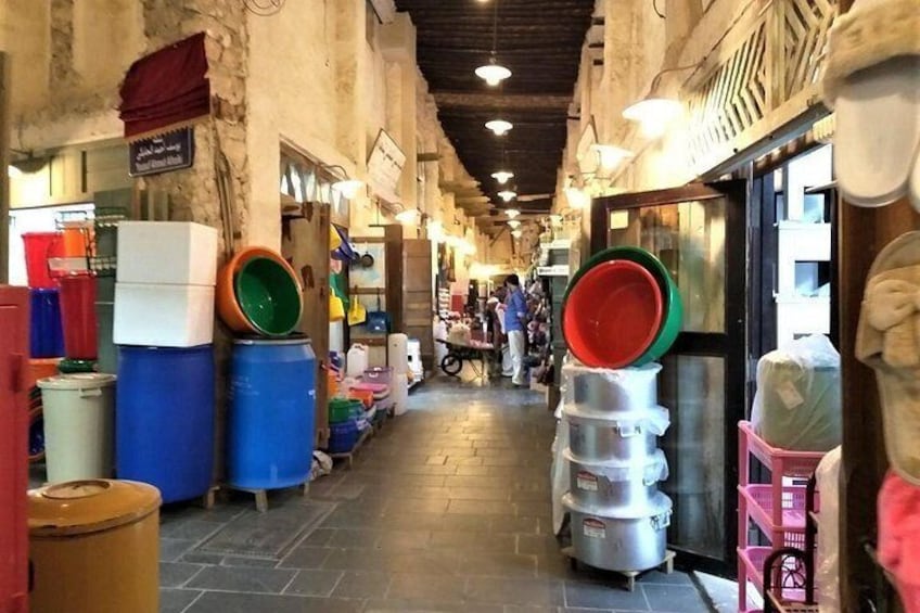A narrow market corridor with various stalls and containers. 5