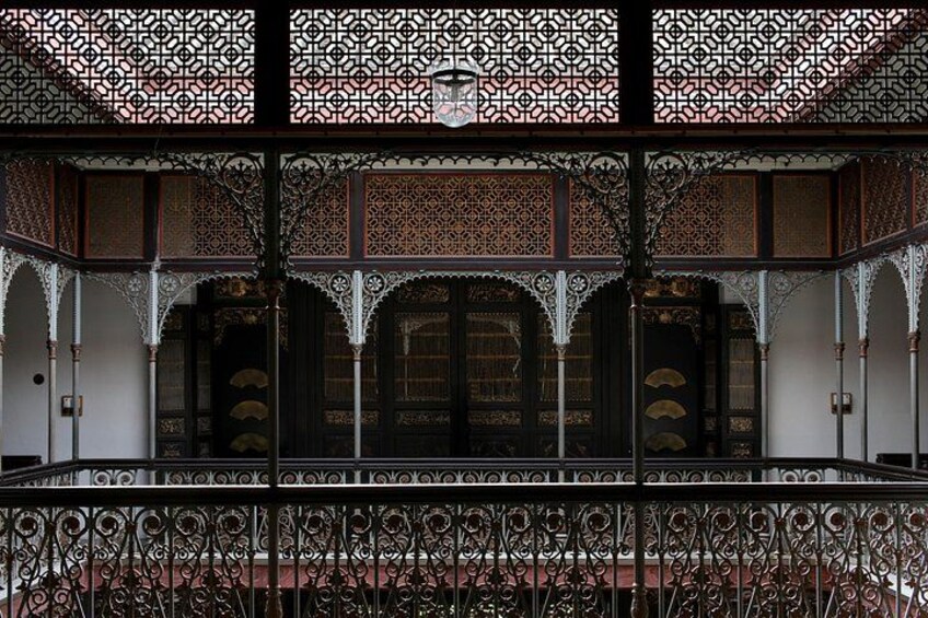 A traditional building with ornate lattice work, arched doorways, and a balcony with intricate railing. 2