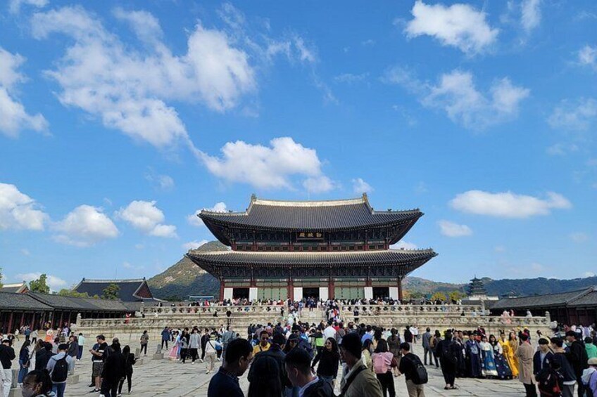 A traditional Korean palace with a large crowd in front. 3