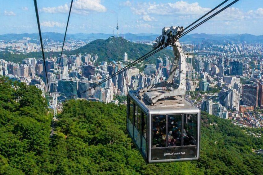 Un teleférico con un paisaje urbano de fondo. 3