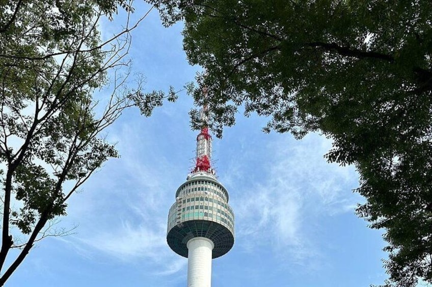 Ein Turm mit einer roten Turmspitze, umgeben von Bäumen. 2