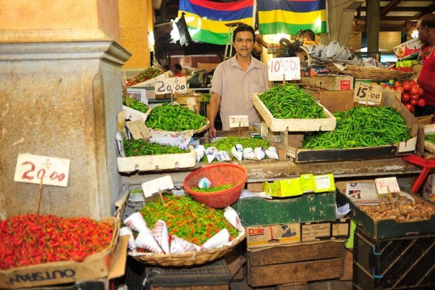 A market with various vegetables on display, including green beans and tomatoes, with price tags visible. 4