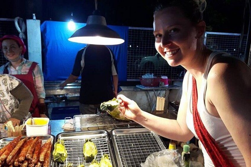 A person grilling food outdoors at night. 3