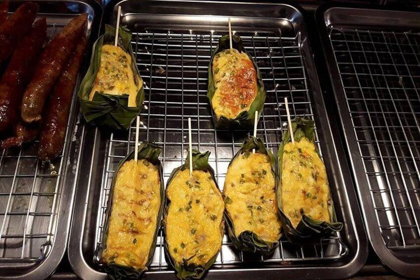 Grilled food items, including sausages and stuffed vegetables, on a metal rack. 4