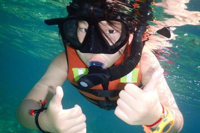 A person underwater, wearing a snorkel and a life vest. 2