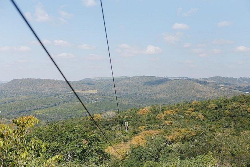 A cable car system, a hilly landscape, and a clear sky. 1
