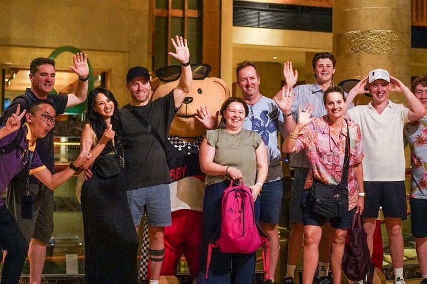 A group of people posing for a photo in an indoor setting with a large, decorative column in the background. 4
