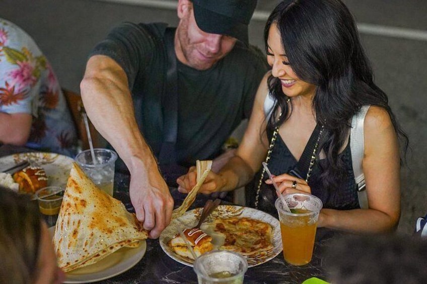 Personas cenando en una mesa con comida y bebidas. 5