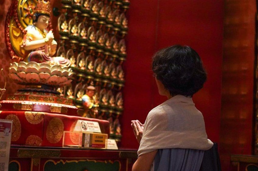 A child praying in front of a statue in a temple. 3