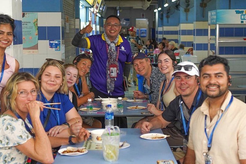 A group of people sitting at a table in a restaurant with blue walls and tiled floors. 4
