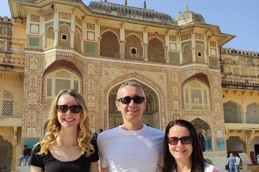 A group of people in front of a historic building with intricate architecture. 1
