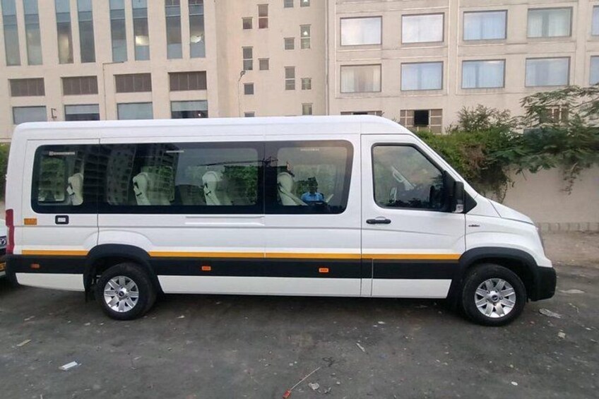 A white van parked in an urban area with buildings in the background. 4