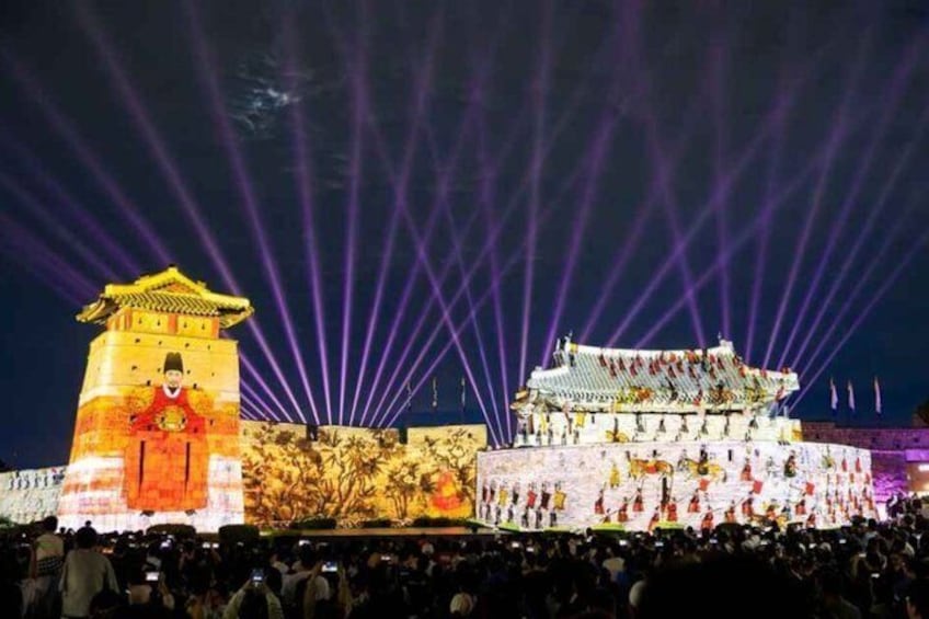 A traditional building with illuminated projections and a crowd of people. 2