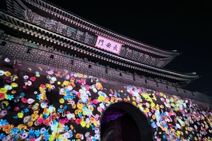 A traditional Chinese building with a signboard and a colorful floral display. 4