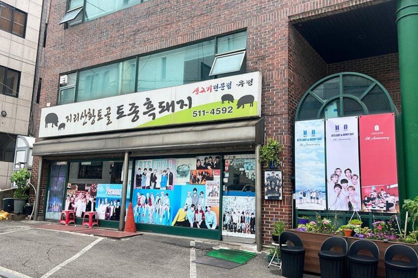A building with a signboard, posters, and a green awning. 5