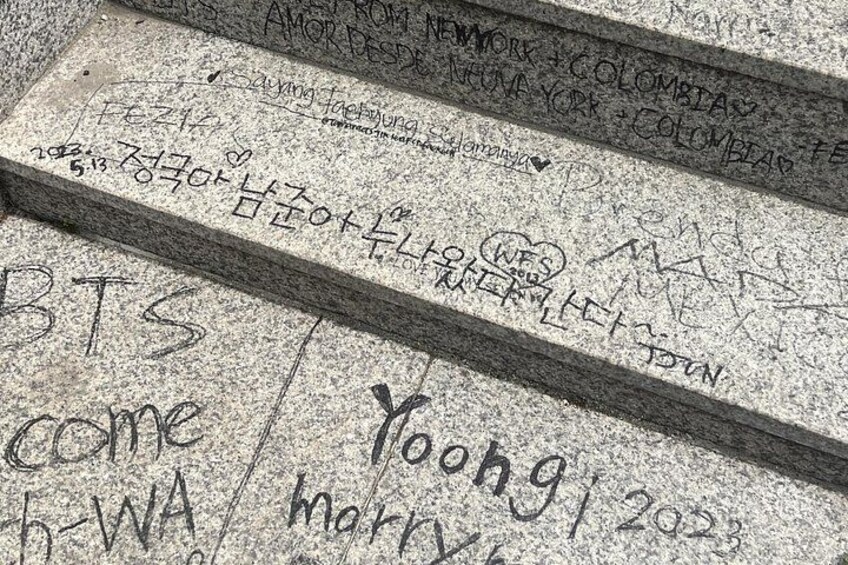 A stone with inscriptions, including 'BTS come' and 'Yoohg 2023'. 4