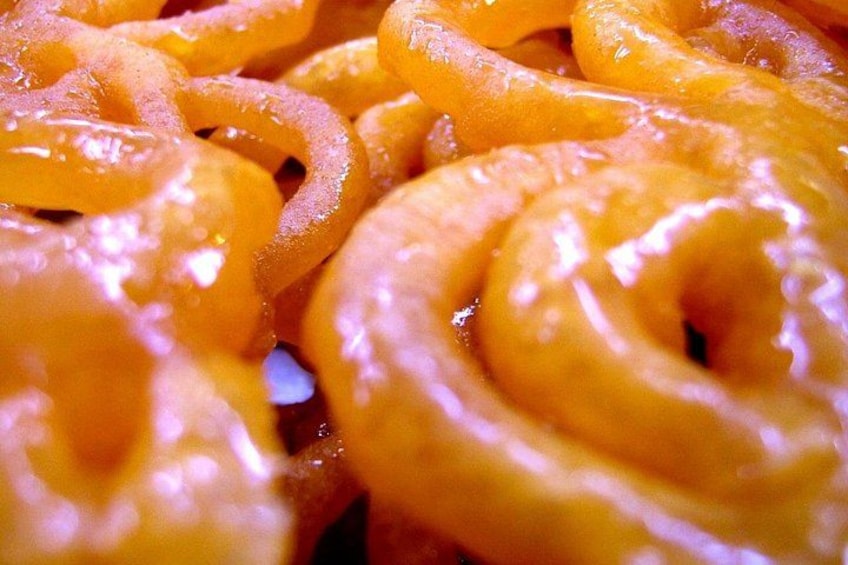 A close-up of glazed doughnuts with a shiny, sugary coating. 1