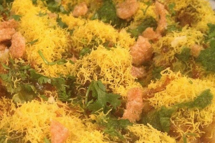A close-up of sev and shrimp on a bed of rice. 2