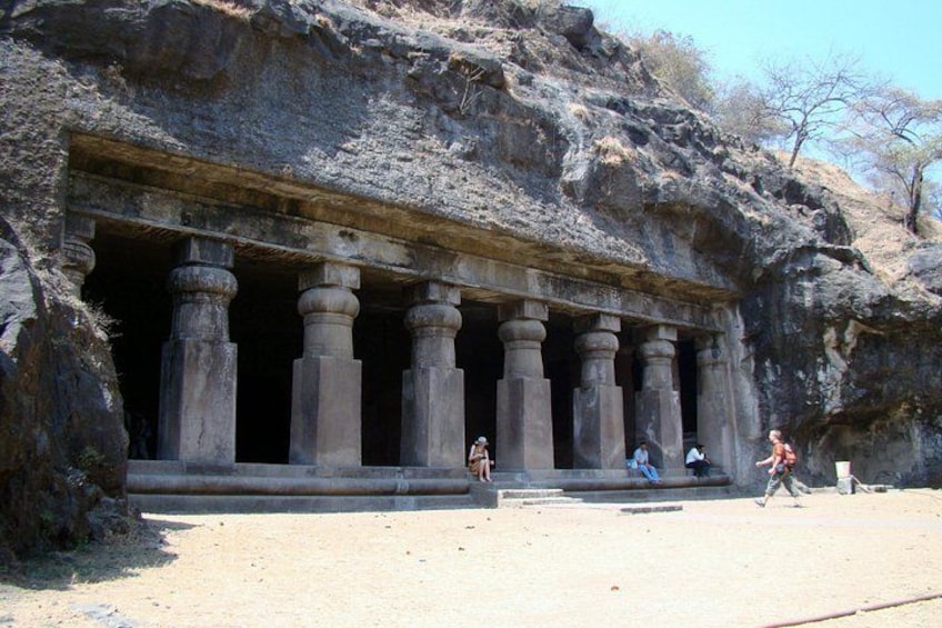 Una gran entrada a un templo tallado en la roca, con múltiples columnas. 3