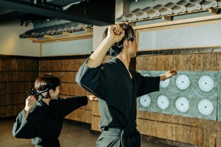 A martial arts training session with a wooden backdrop and a patterned wall. 5