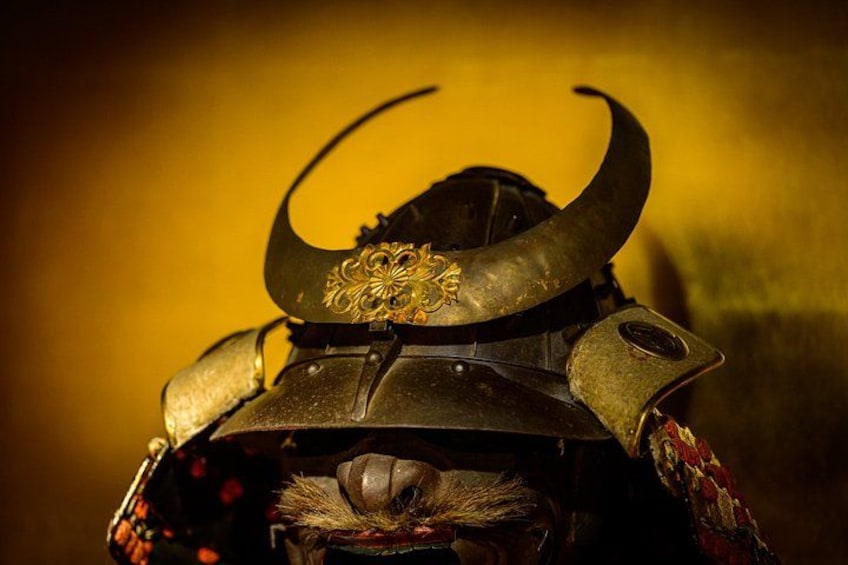 Gros plan d’un casque de samouraï orné d’une corne incurvée et d’éléments décoratifs. 5