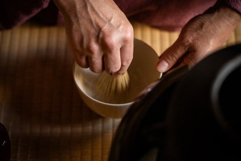 A person whisking a liquid in a bowl. 3