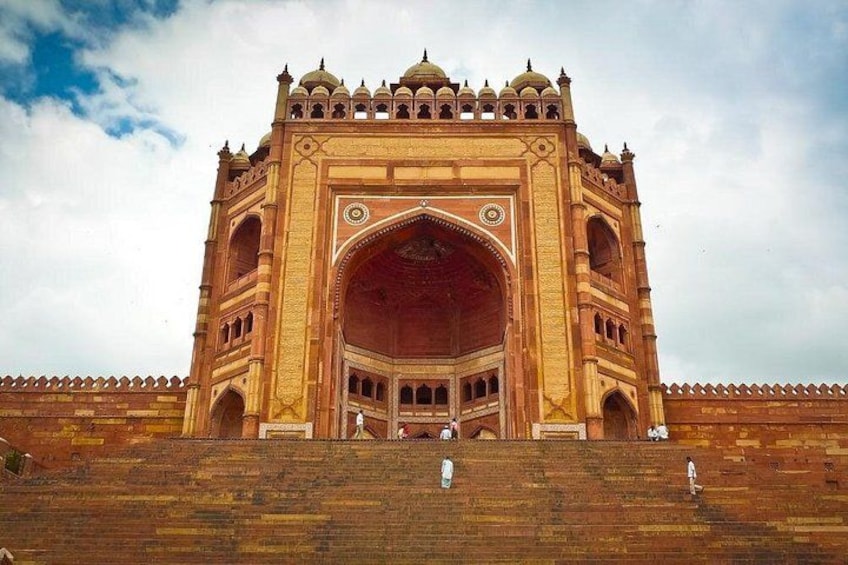 A large, ornate building with a central archway, multiple domes, and a series of smaller arches around the perimeter. 2
